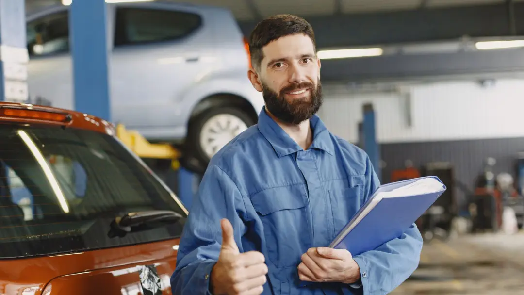 Certified technician at BC Auto Glass giving a thumbs-up beside a vehicle.